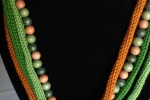 Collana in tubolare di cotone e perle di legno nei colori verde e mattone.