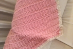 Copertina in lana rosa con bordo bianco