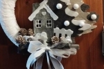 Ghirlanda fuoriporta natalizia decorata con alberi casette