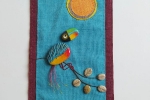 Pannello di stoffa con sassi di mare dipinti uccello di fantasia