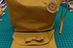 Pochette gialla realizzata in similpelle con ciondolo e manico
